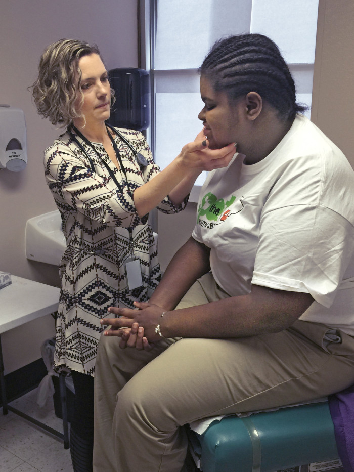 Sarah Garwood, MD, examines Jennings Senior High School senior Autumn Dixon during a visit to the school's clinic. 