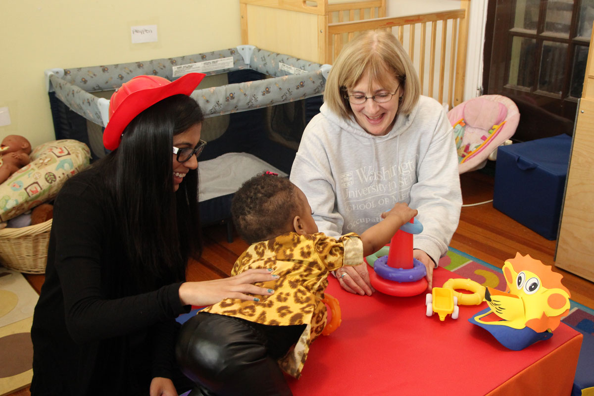 Washington University's Christine Berg (right) and occupational therapy doctoral student Jaya Bhakta involve preschooler C'dora Gilliam in active play at Our Daycare in Normandy. Occupational Therapy students work with children at the center on a range of developmental activities, among them physical behaviors aimed at preventing obesity and other problems later in life.