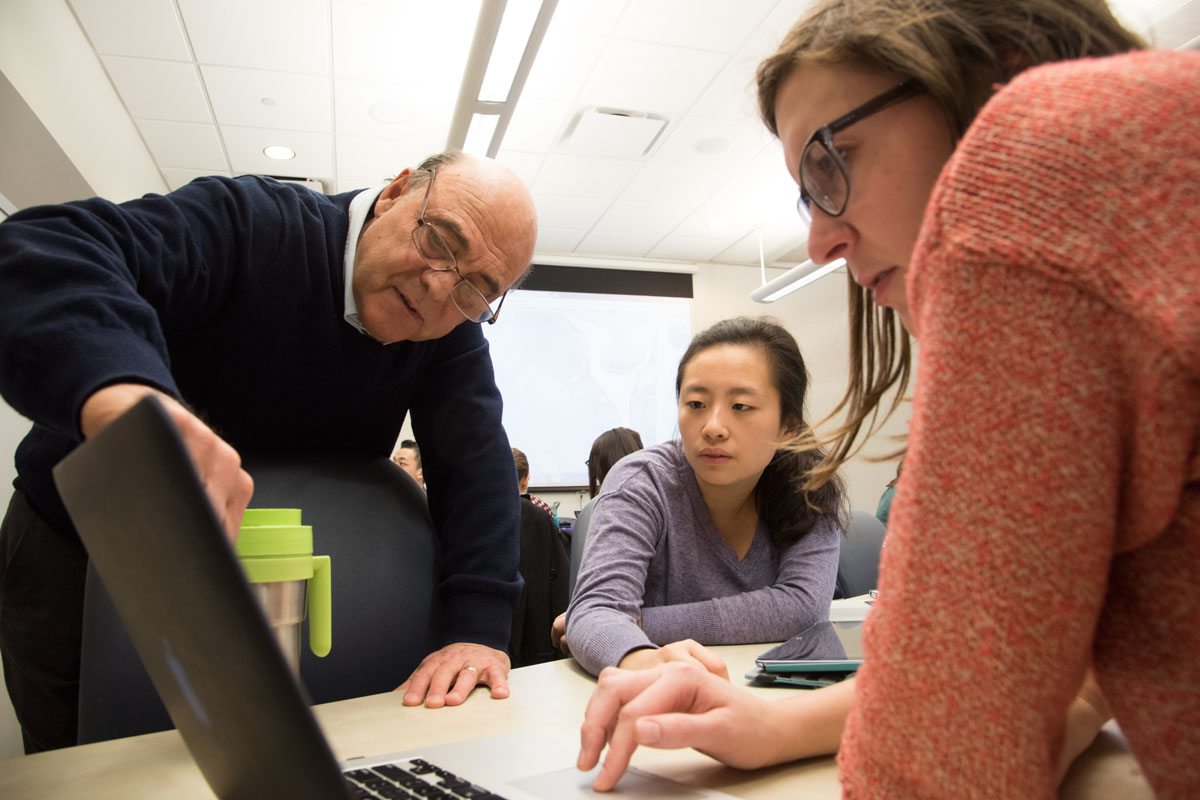 From the left, Krikor Dikranian, MD, PhD, discusses a slide in the histology iBook with medical students Jaclyn Yu and Bronwyn Bedrick.