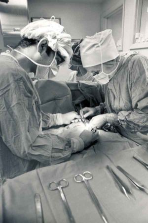 Jessie L. Ternberg, PhD, MD, (left) performs surgery.