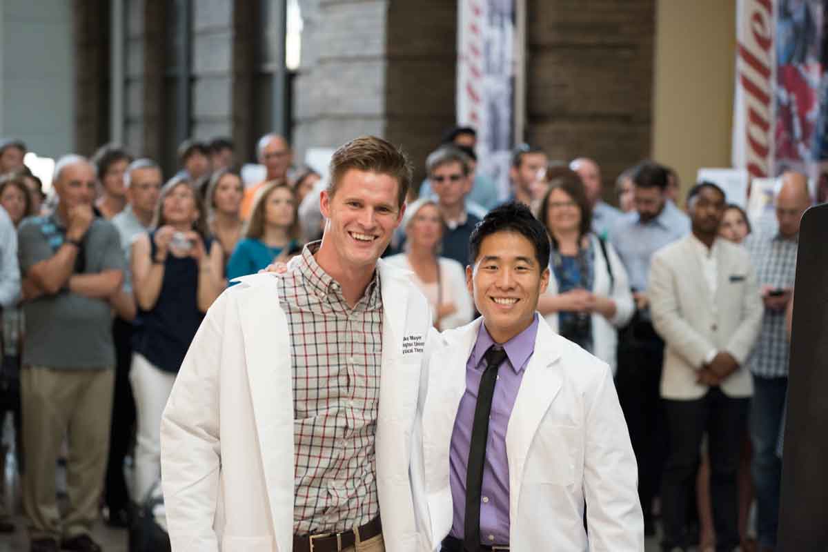 Second-year physical therapy student Luke Mayer (left) celebrates at the White Coat Ceremony with Keaton Kong, a first-year student in the program.