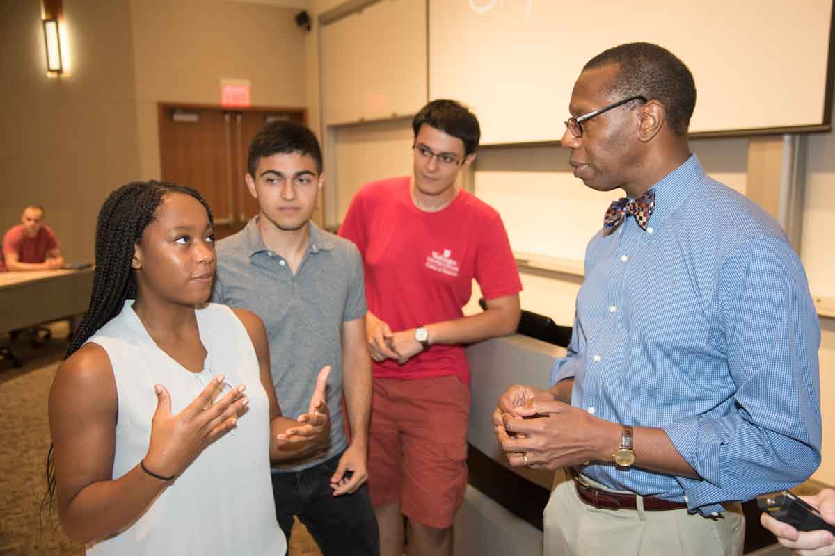 Will Ross, MD, who created and leads the Washington University Medical Plunge (WUMP) program, discusses social determinants of health with first-year medical students (from left) Marlene Kanmogne, Michael Veshkini, and Artem Arutyunov during the orientation.