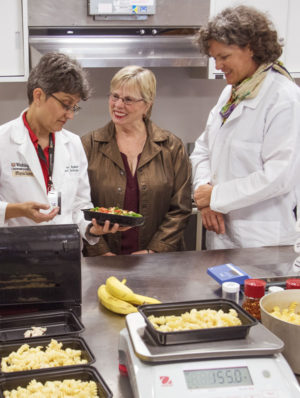 Dietitian Sue Waller (left) shows a meal to Mary Akin (center), one of the patients in a study conducted by Bettina Mittendorfer, PhD. Women in the study were provided food over the course of the research.