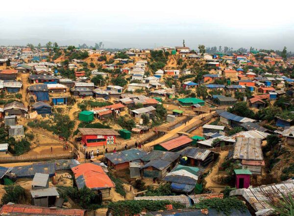 Hundreds of colorful huts cover muddy hillsides at Rohingya camp on the Bangladesh-Myanmar border.