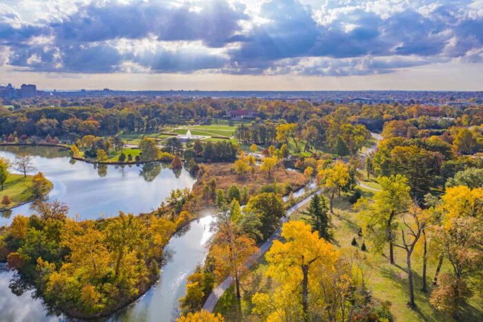 Aerial of view of Forest Park, with views of trees, waterways, and the downtown skyline in the distance