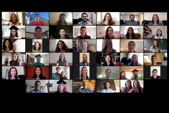Screenshot of a Zoom call shows a grid of 32 smiling students ready to graduate