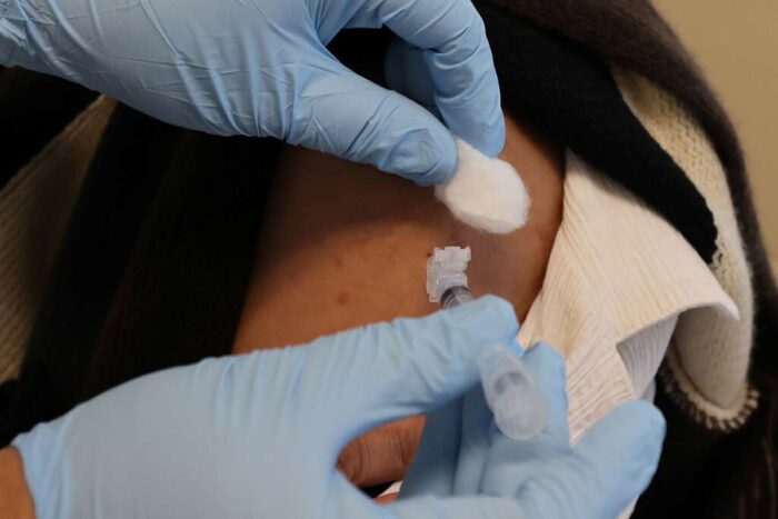 Closeup photo of someone receiving a vaccination in upper arm