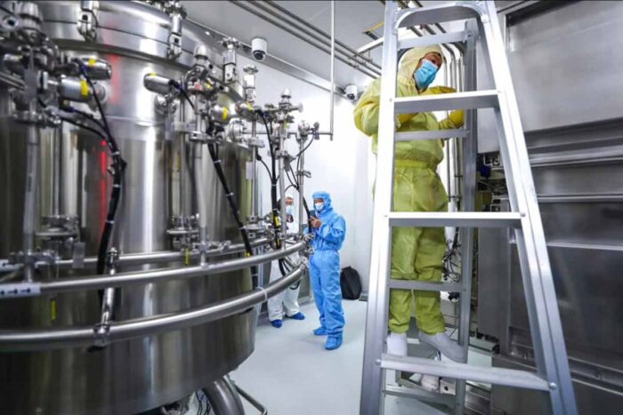 Staff members check and clean equipment at a vaccine production plant operated by SinoPharm in Beijing.