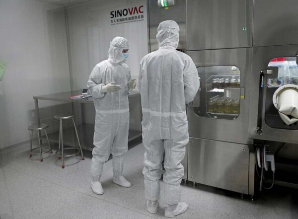 Researchers in full body PPE Inside Sinovac Biotech’s factory in Beijing in September.