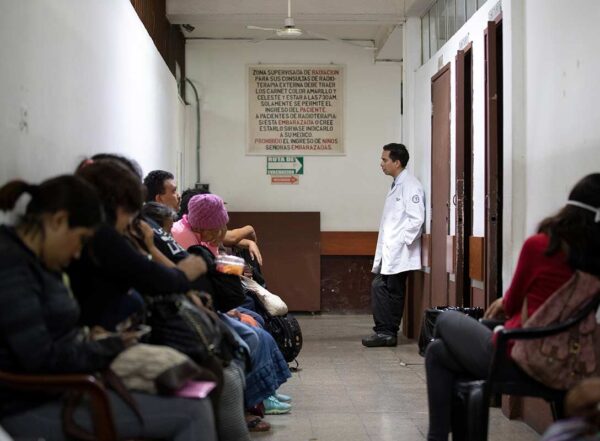 Angel Velarde, MD, research director at the Instituto Nacional de Cáncerologia (INCAN), stops in a hallway to speak with patients waiting for radiation therapy. Patients are treated on a first-come, first-served basis and waiting rooms quickly fill up.