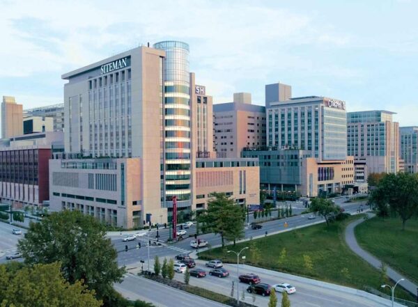 Aerial photo of the northwest are of the Medical Campus shows stone and glass buildings in the rosy glow of twilight