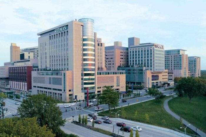 Aerial photo of the northwest are of the Medical Campus shows stone and glass buildings in the rosy glow of twilight