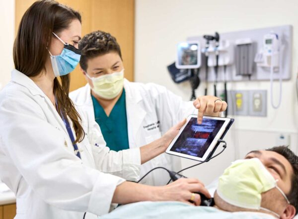 Hospitalists Crystal Atwood, MD (left), and Stephanie Conner, MD, use POCUS (point-of-care ultrasound).