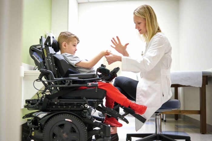 Alumna Lindley Wall, MD, examines the arms, wrists and hands of Alexander Trudo, 9, at St. Louis Children’s Hospital.