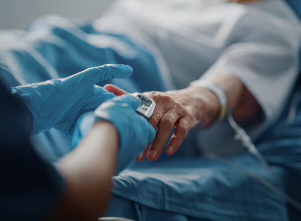 Patient with oximeter lying in a hospital bed