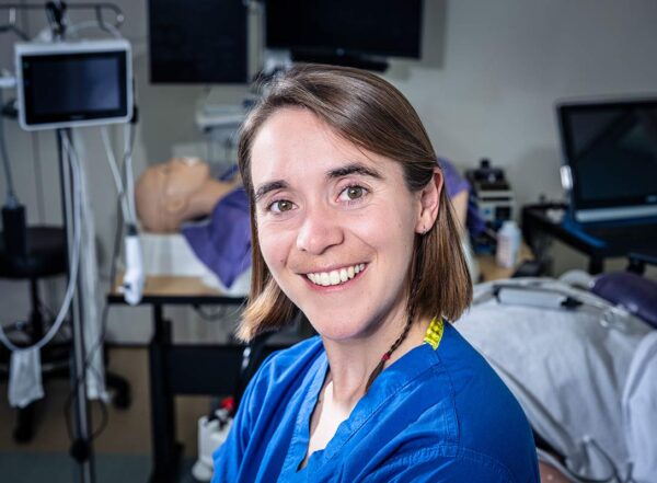 WashU medical student Caellagh Catley wearing blue scrubs in a mock operating room