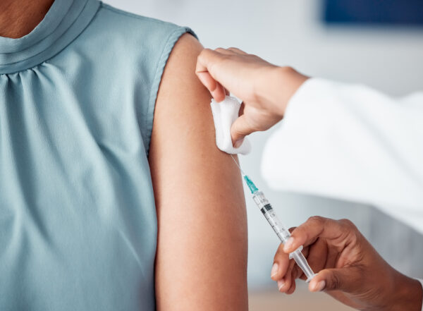 image of a medical professional using a needle to inject vaccine into patient's arm