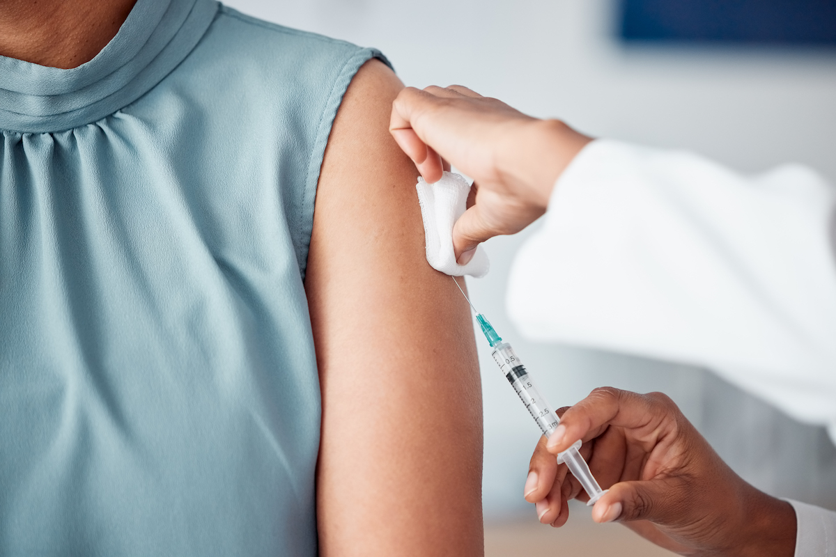 image of a medical professional using a needle to inject vaccine into patient's arm