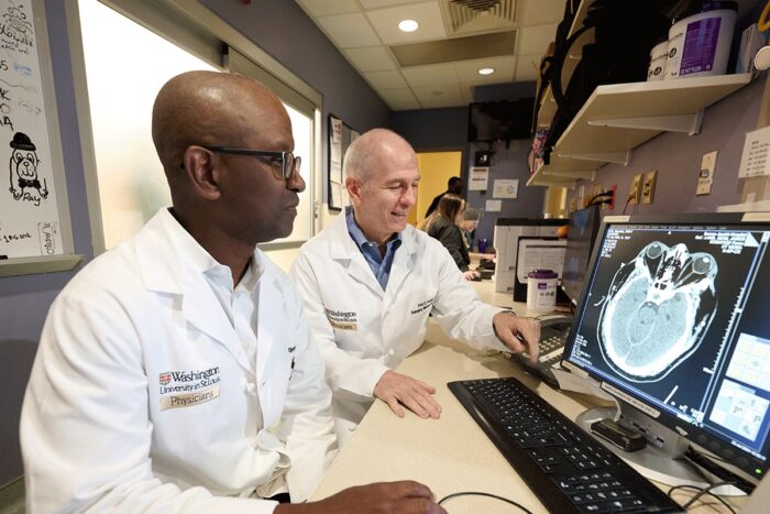 Opeolu Adeoye, MD, and Peter Panagos, MD, both professors of emergency medicine at Washington University School of Medicine in St. Louis, analyze a brain scan for stroke damage.