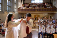 Student receives white coat on stage