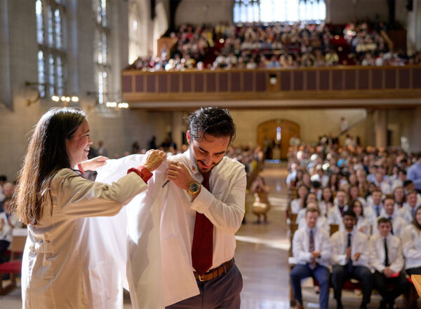 Student receives white coat on stage