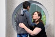 kneeling pediatrician loops up at young patient