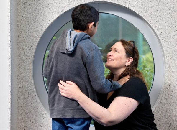 kneeling pediatrician loops up at young patient