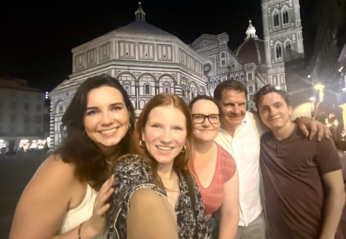 a family posing in front of cathedral in italy