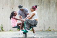 Michael Rall-Brown plays with his daughters at the Dennis & Judith Jones Variety Wonderland Playground in Forest Park