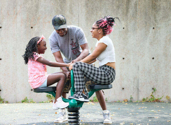 Michael Rall-Brown plays with his daughters at the Dennis & Judith Jones Variety Wonderland Playground in Forest Park