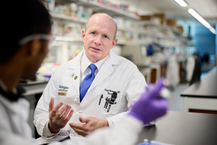 Randall J. Bateman, MD, speaking with a colleague in the lab