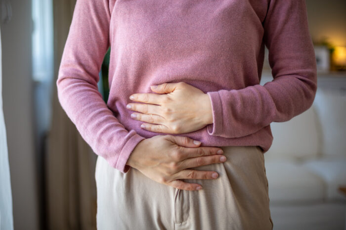 Adult woman holding her belly suffering from abdominal pain