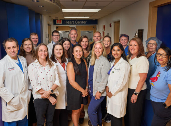 Doctors and other clinical staff posing for photo in hospital hallway
