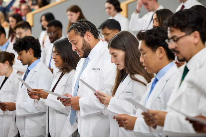 First-year medical students reading from card