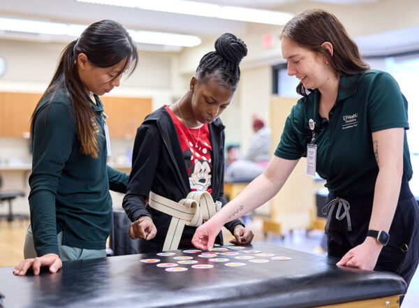 Lapada Pavanacharoensuk and Mackenzie Halton help a patient at the Pro Bono Health Clinic