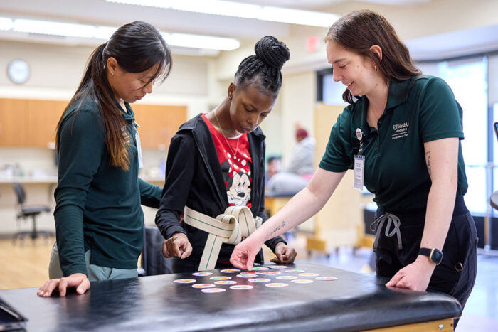 Lapada Pavanacharoensuk and Mackenzie Halton help a patient at the Pro Bono Health Clinic