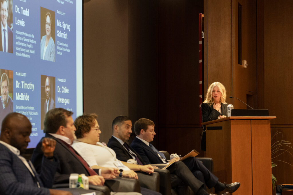 Margaret Kruk (right) introduces panelists for a discussion on challenges facing health systems