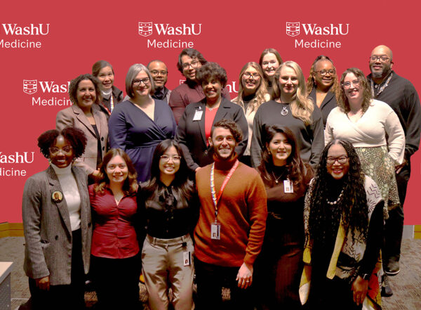 Group of WashU faculty, staff and students pose in front of WashU Medicine sign