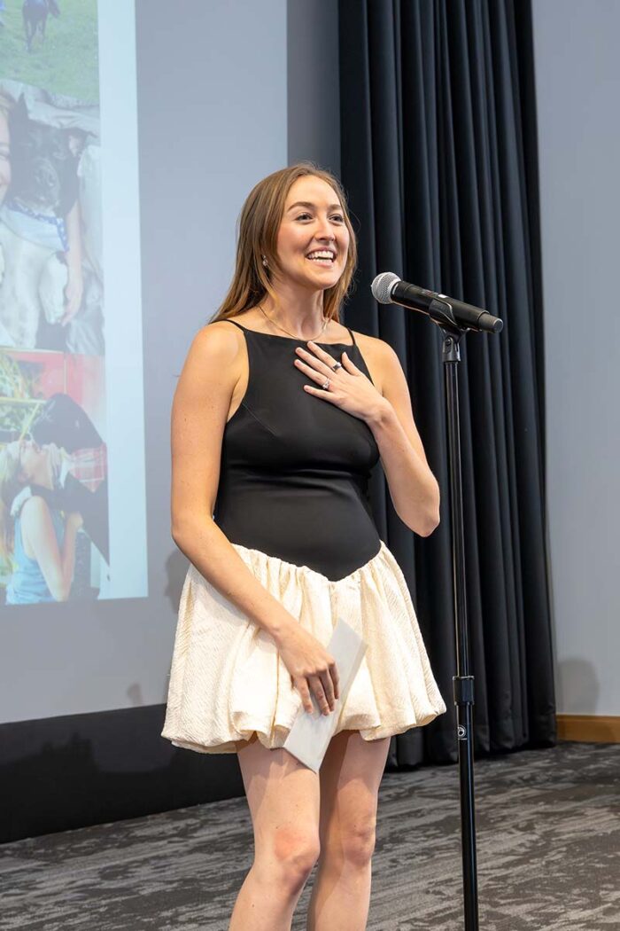 Medical student stands on stage to announce where she matched