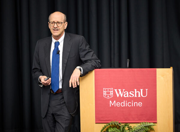 Dean in suit speaking at WashU Medicine lectern