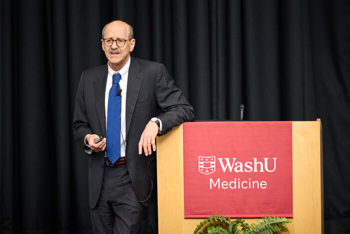 Dean in suit speaking at WashU Medicine lectern