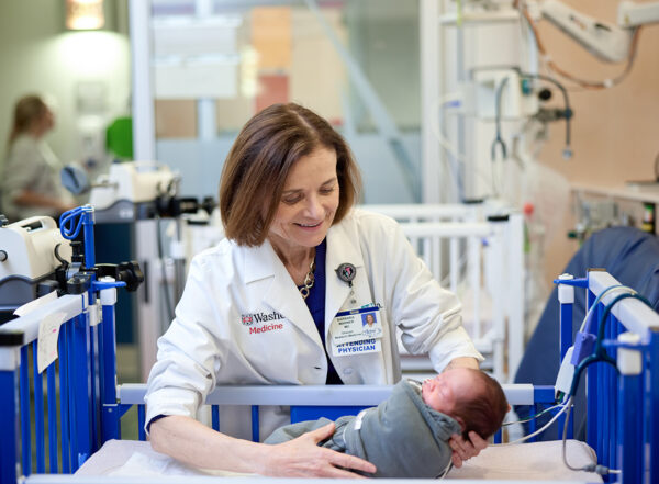 doctor holding a baby in the NICU