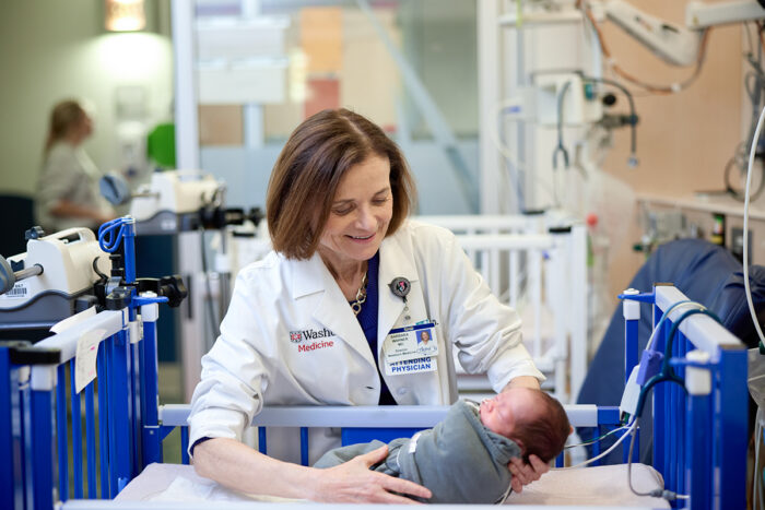 doctor holding a baby in the NICU