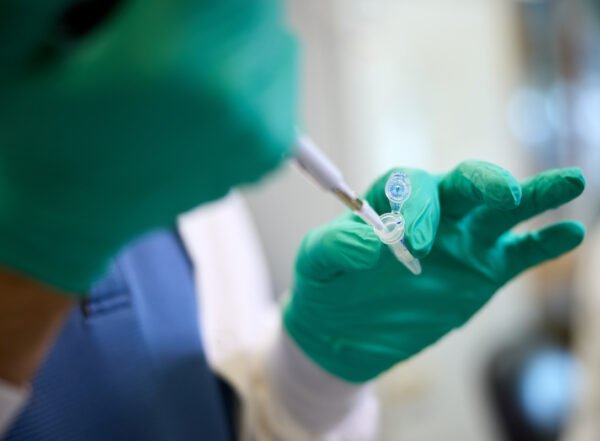 A scientist pipettes in a lab at WashU Medicine