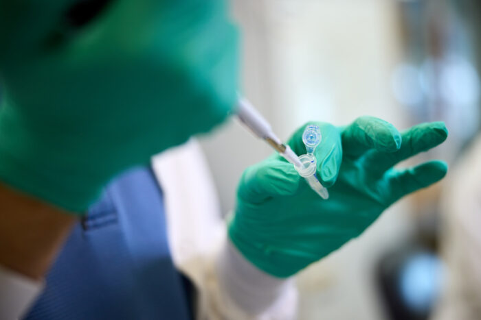 A scientist pipettes in a lab at WashU Medicine