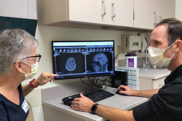 Trial participant Kim Garland reviews a scan with the study’s primary investigator, Tanner Johanns, MD, PhD, a WashU Medicine oncologist.