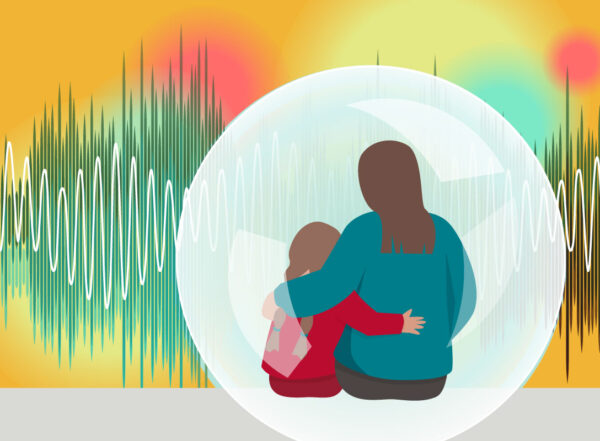 An adult supports a child who is surrounded by many different bright sensory experiences.