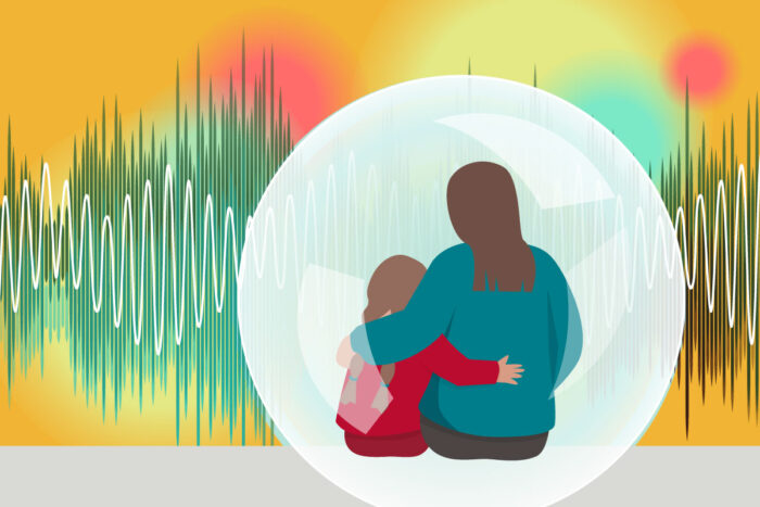 An adult supports a child who is surrounded by many different bright sensory experiences.